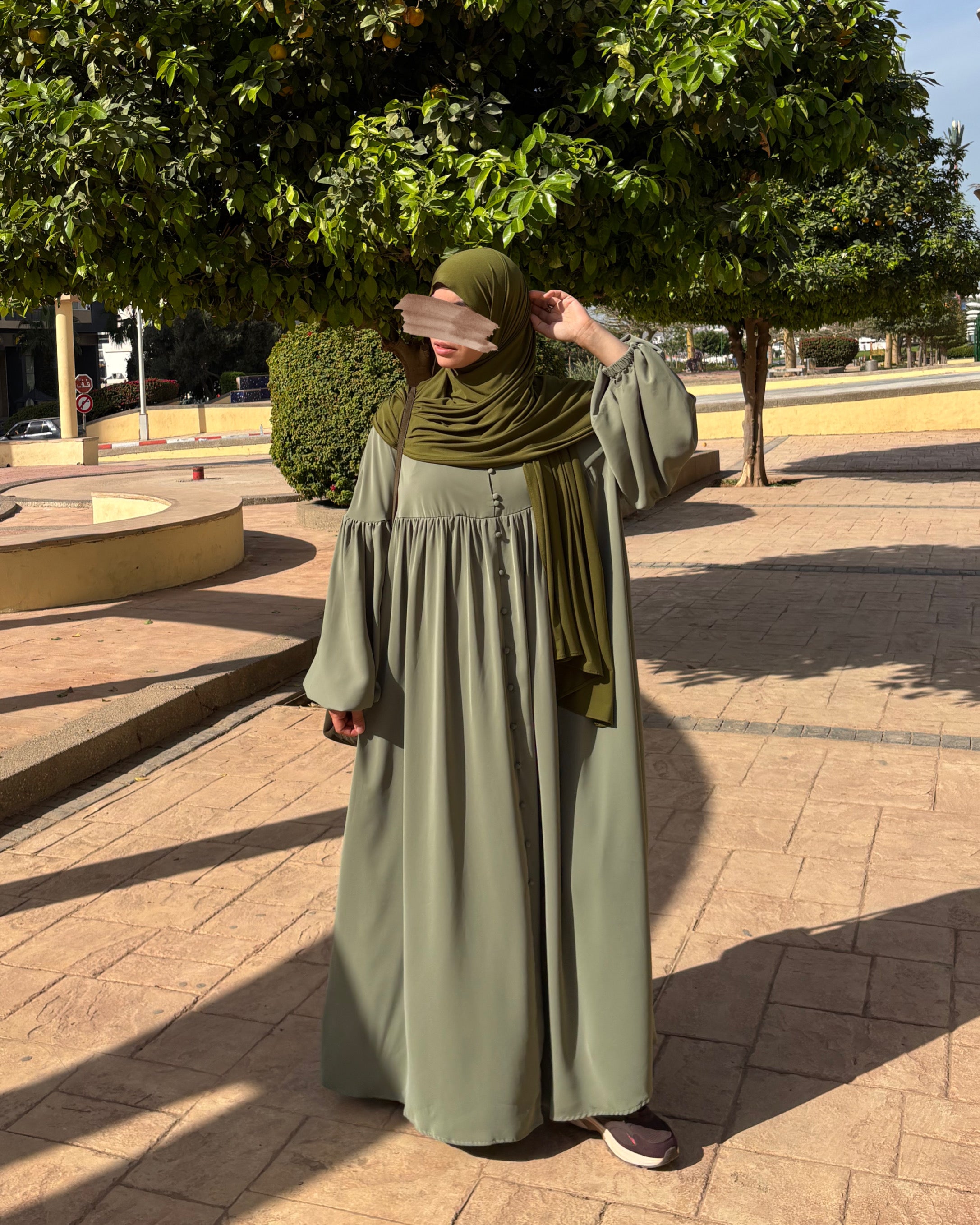 Profil de l’abaya Alya vert sauge, idéale pour apprécier son tombé naturel et sa coupe droite.