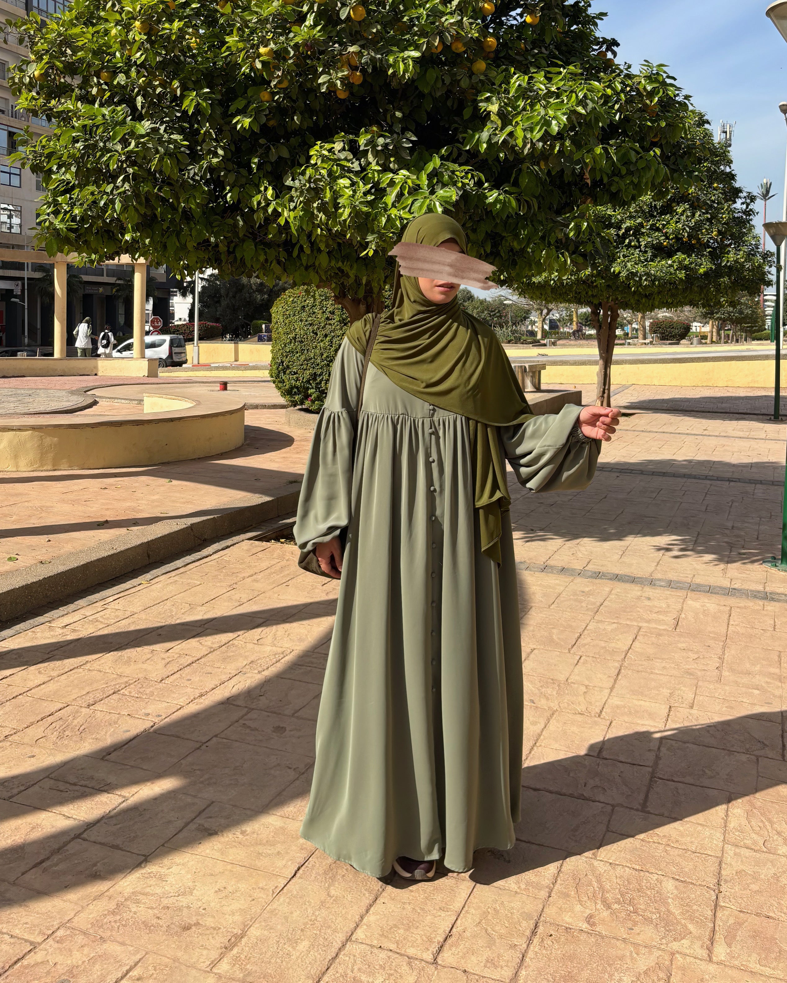 Vue de dos de l’abaya Alya vert sauge, montrant la fluidité du tissu et la longueur élégante.