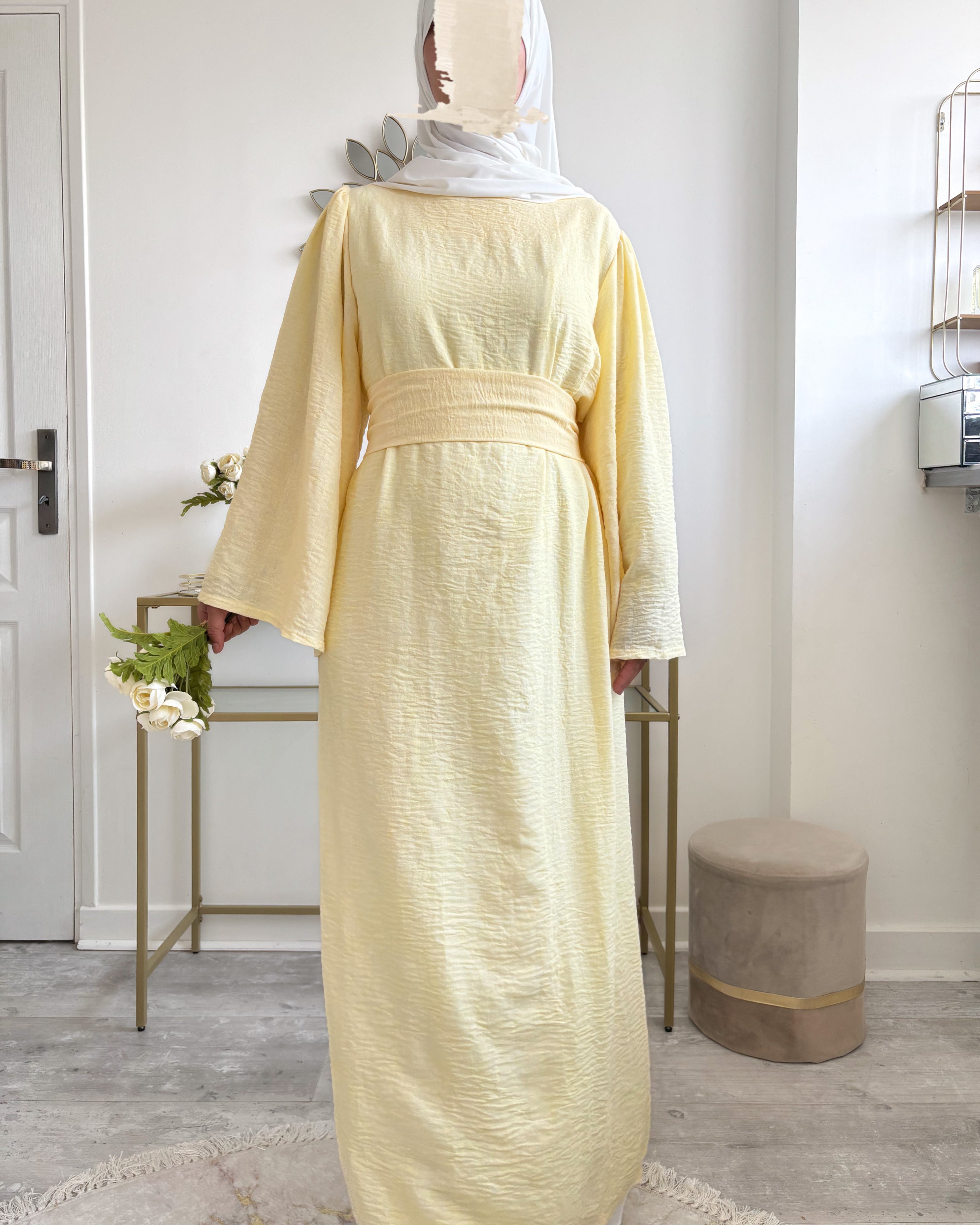 Abaya jaune pâle vue de face, longue et estivale