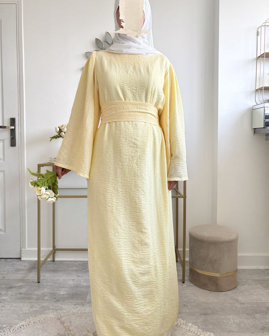 Abaya jaune pâle vue de face, longue et estivale